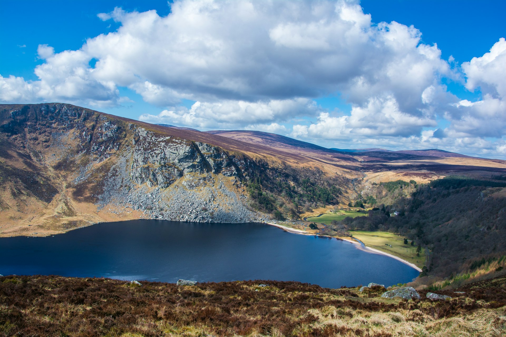 Large white clouds hang over the Wicklow Mountains and below is the sparkling blue waters of Lough Tay