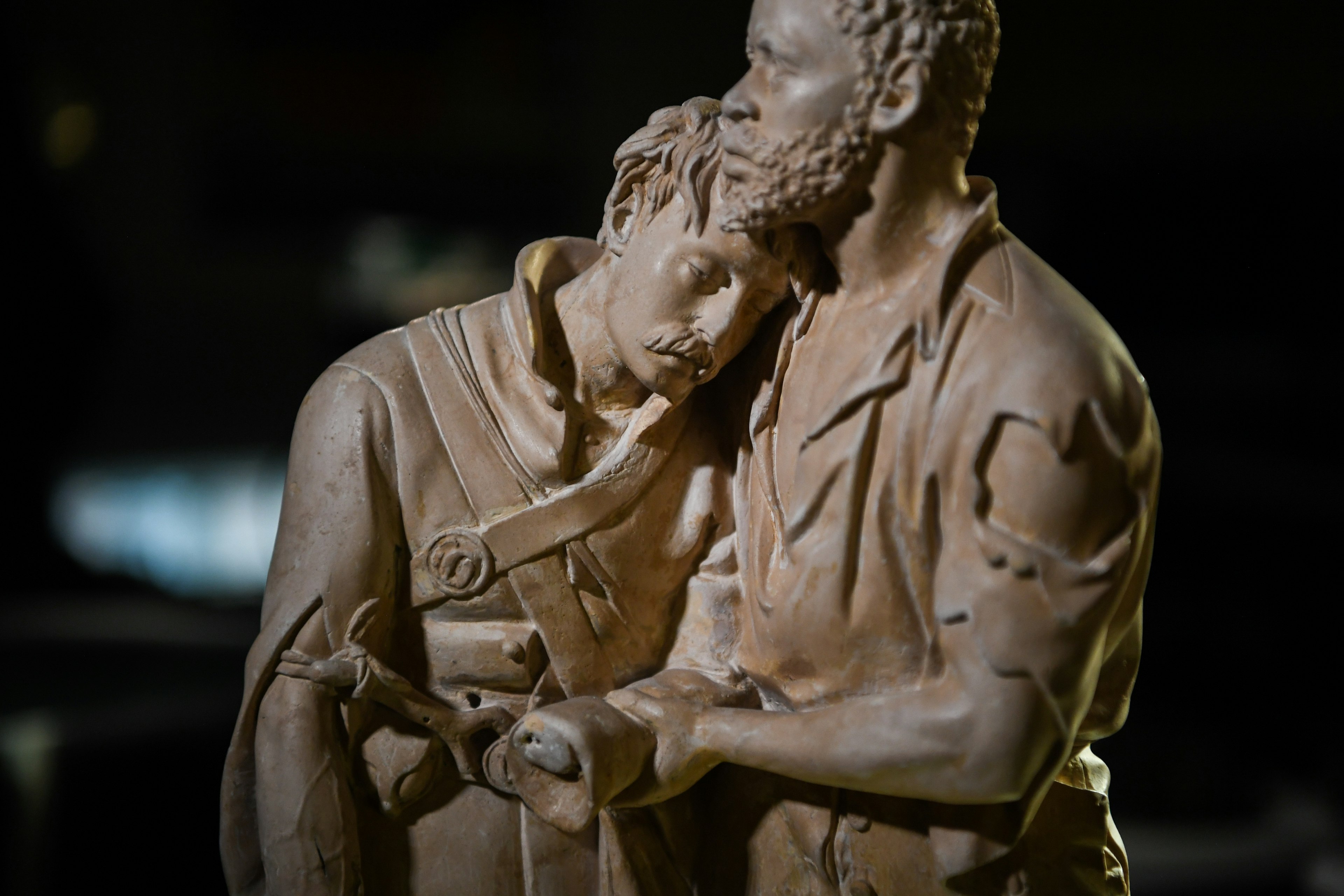 a sculpture of a man holding another injured man