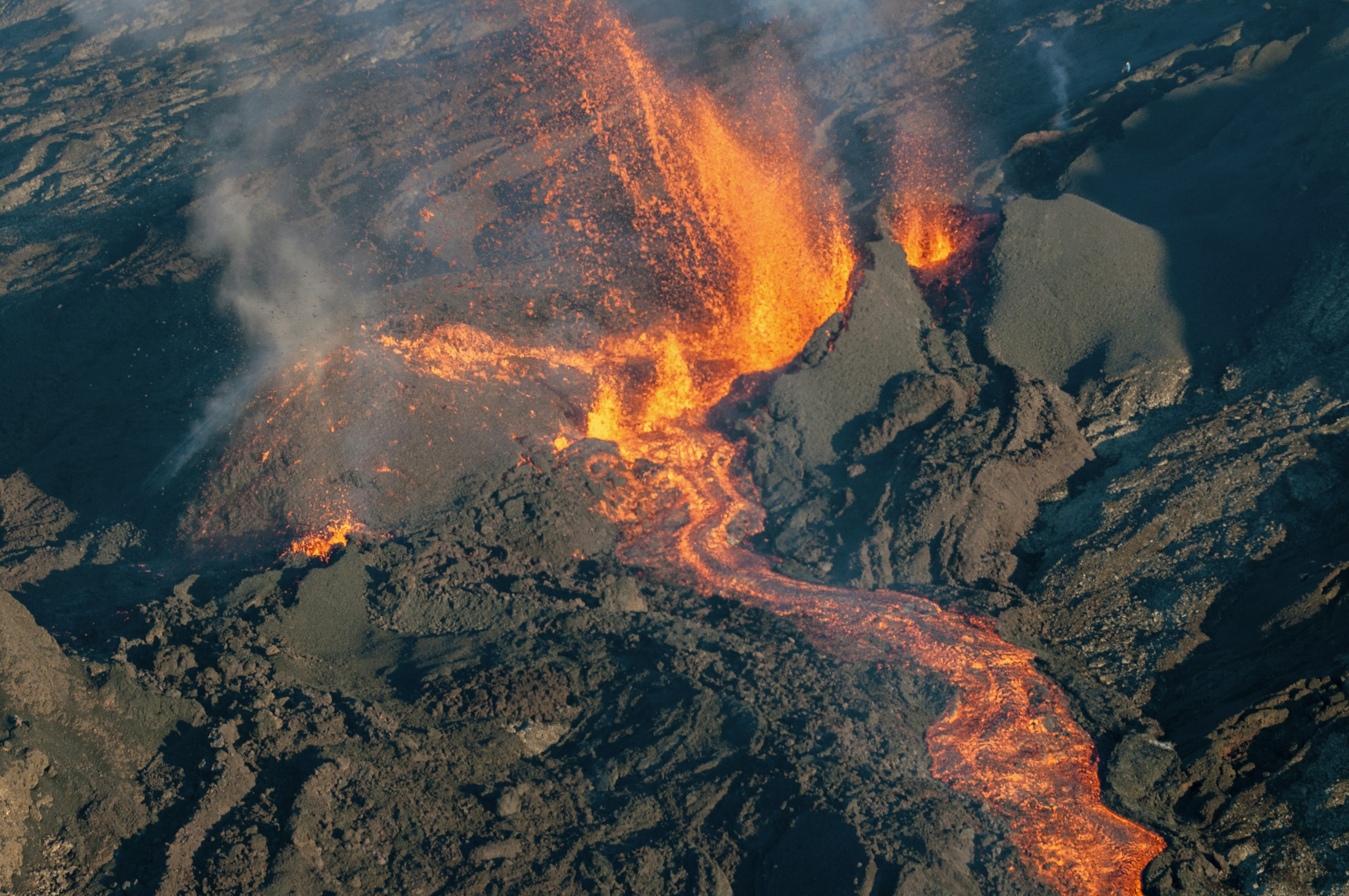 view of hot lava in a volcano surrounded by cold black lava