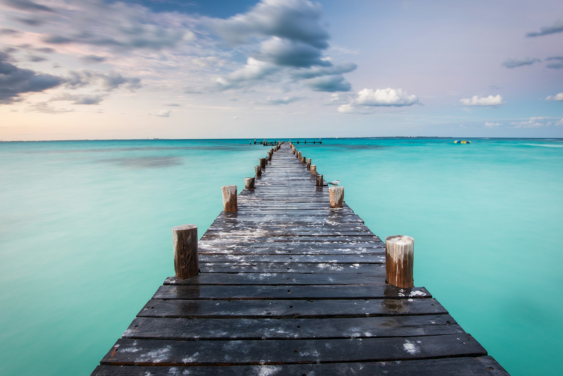 A boardwalk extends into beautiful turquoise water. 