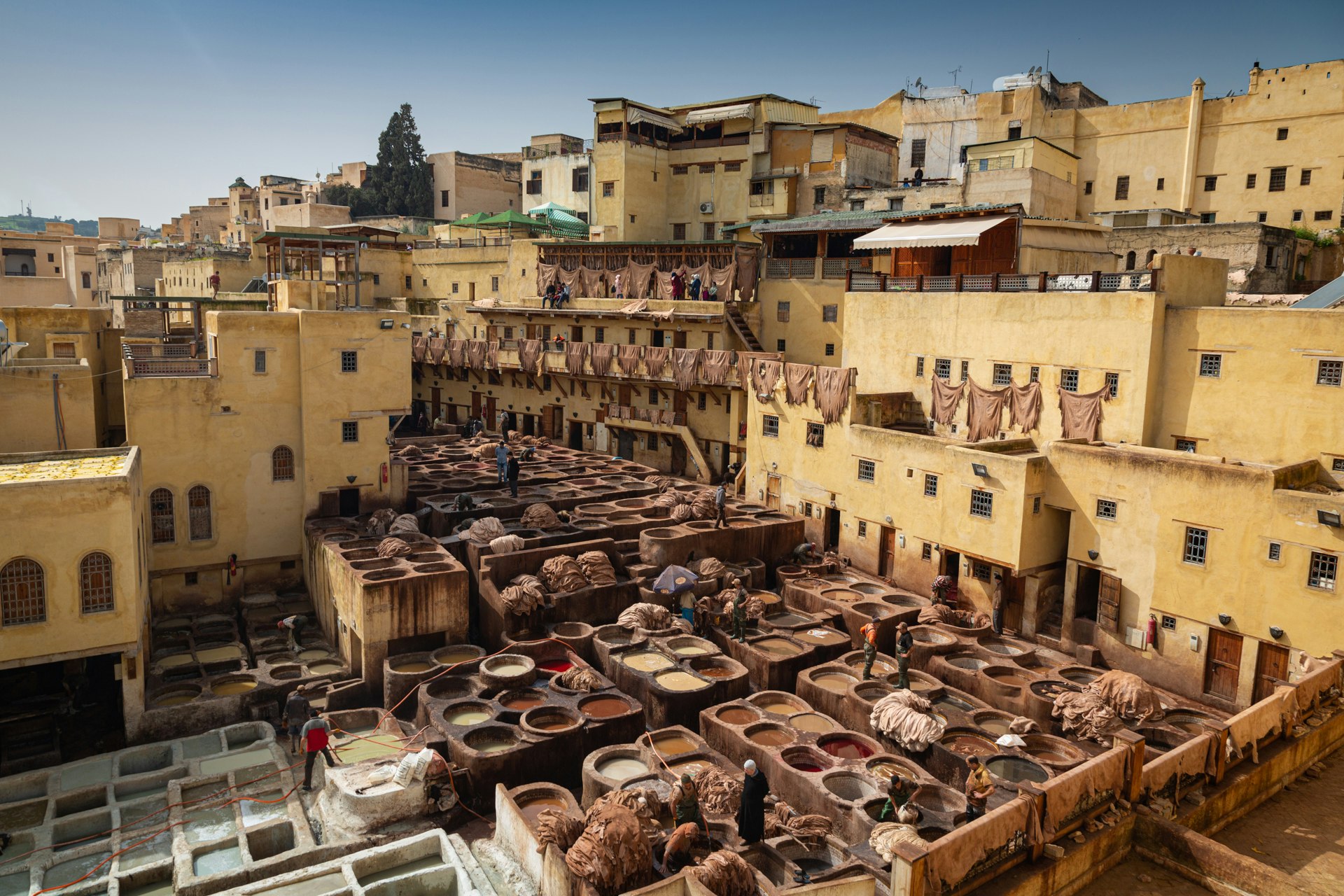 An outdoor tannery in Fez, with large stone vessels filled with dyes