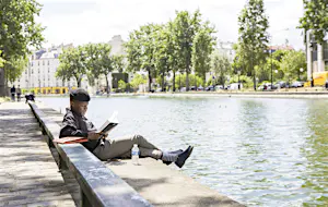 Man reading on banks of Canal Saint-Martin.