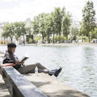 Man reading on banks of Canal Saint-Martin.