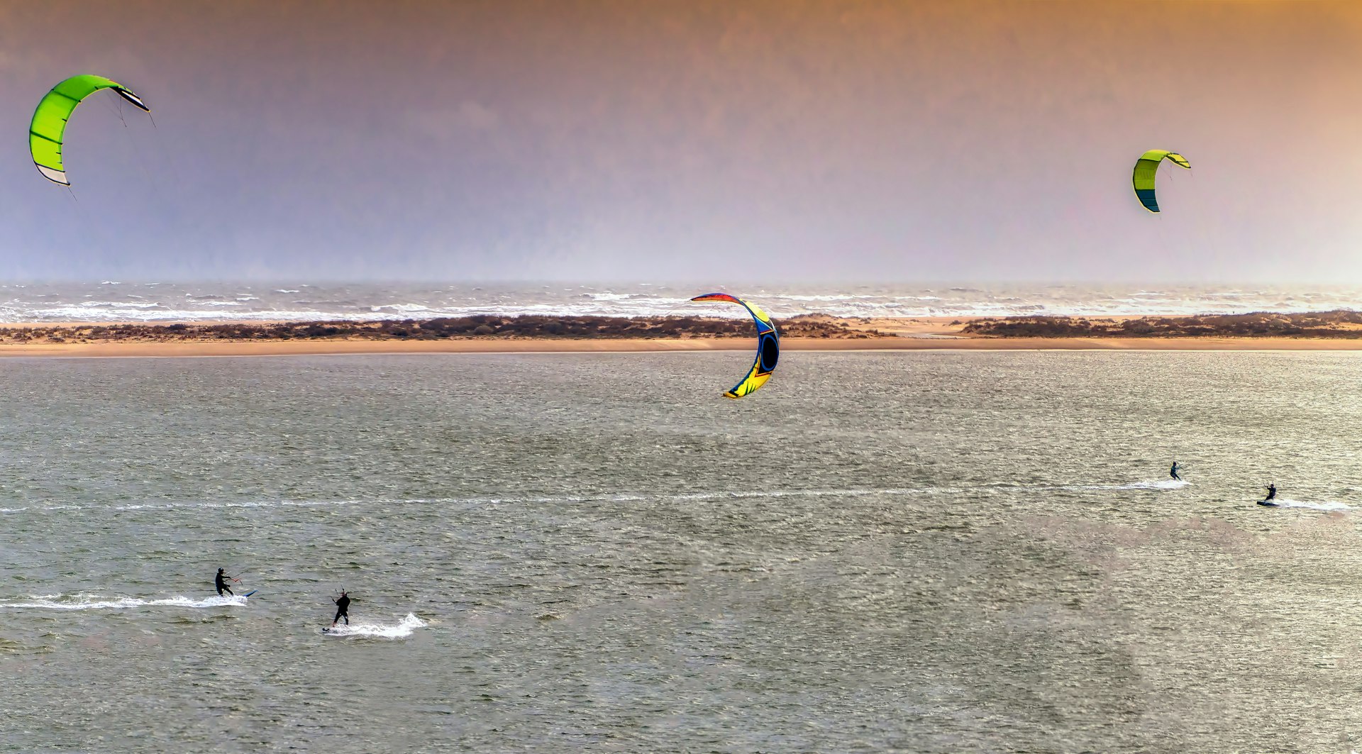 Panoramic view of unidentified people parasailing surfing with windy weather in El Portil, Huelva, Spain.