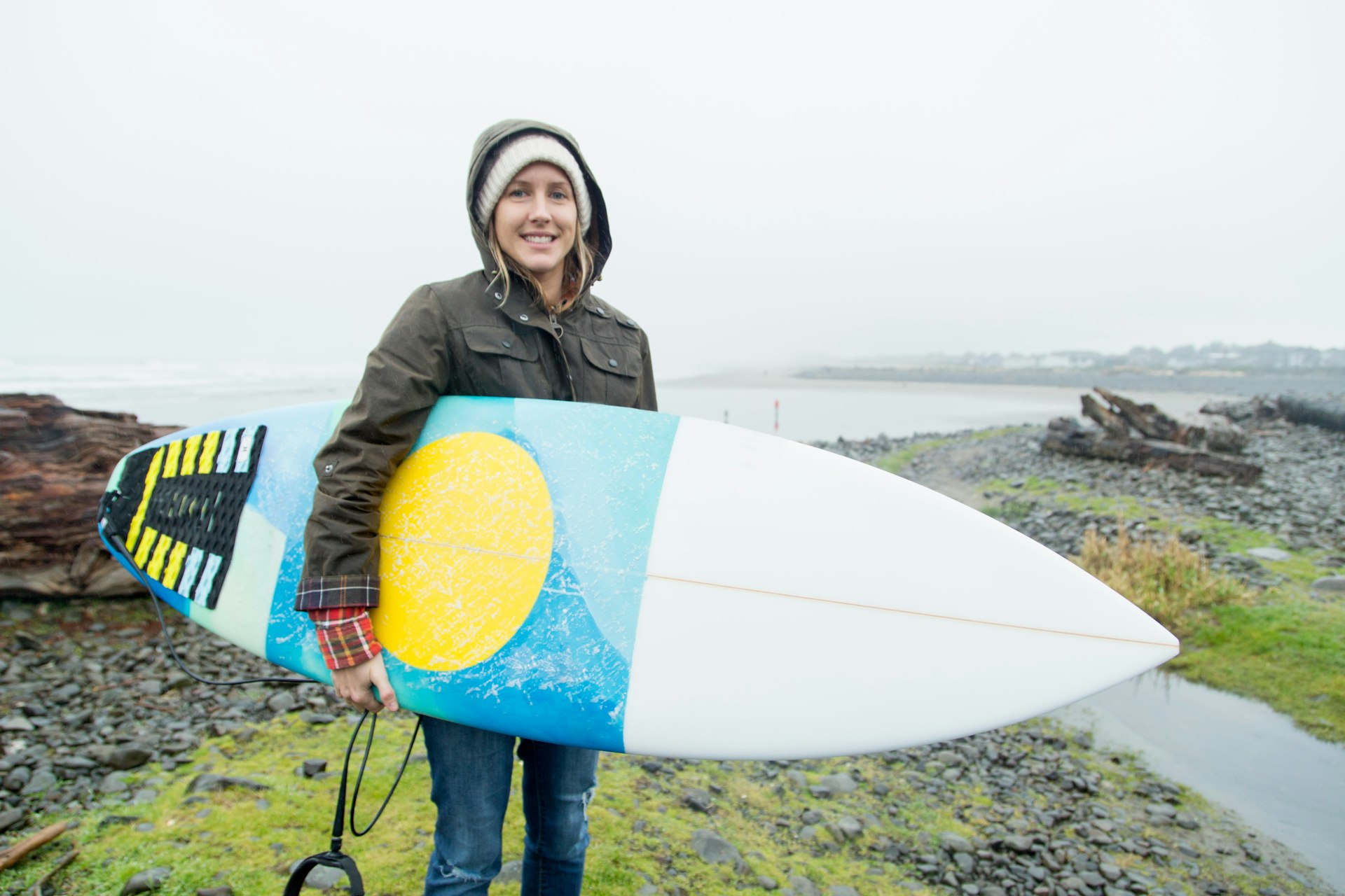 Portrait of female surfer carrying surfboard at coast, Seaside, Oregon, USA