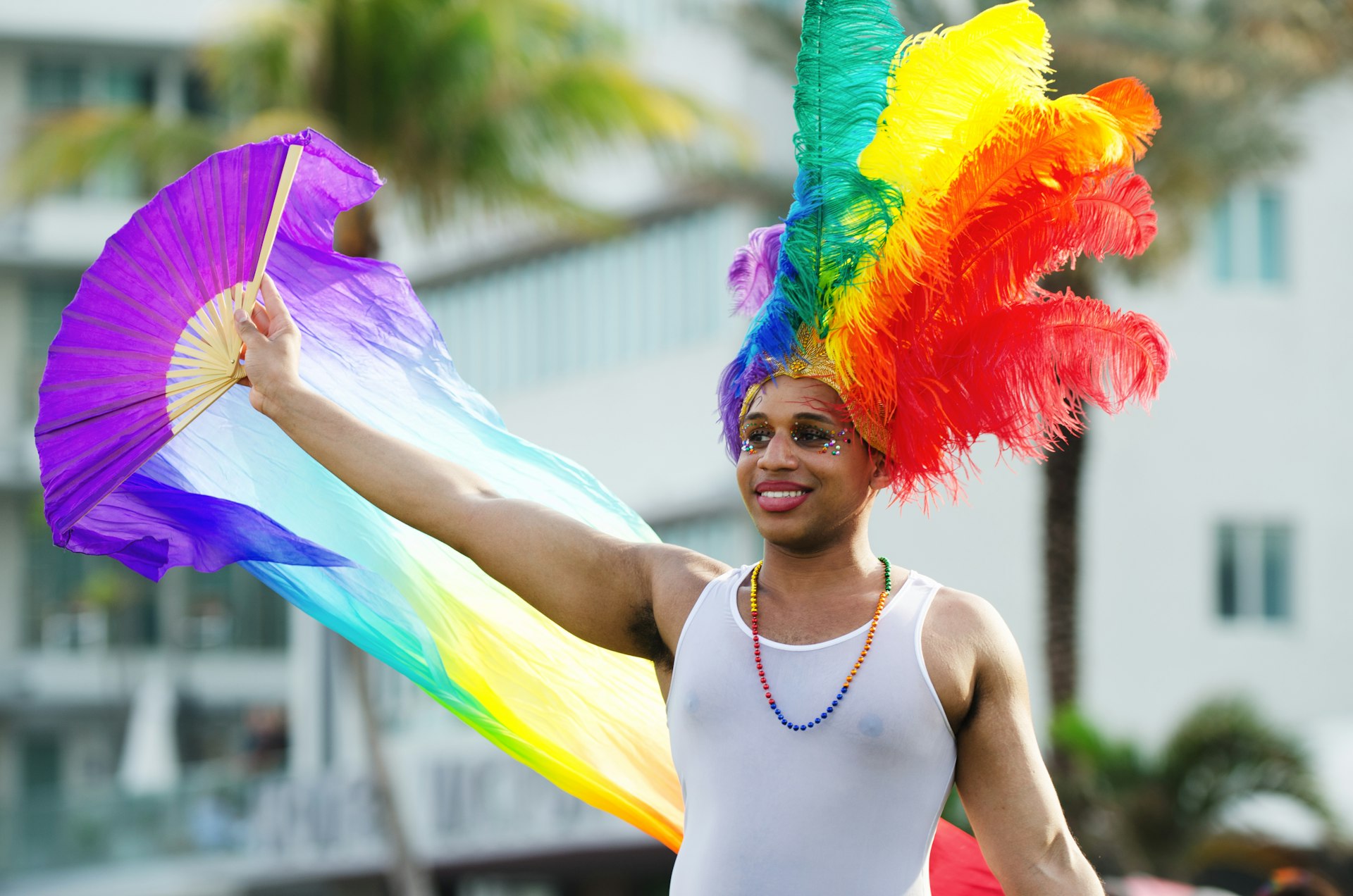 An attendee in rainbow feather hat smiles for onlookers after the annual Miami Beach Gay Pride Parade on Ocean Drive in South Beach.