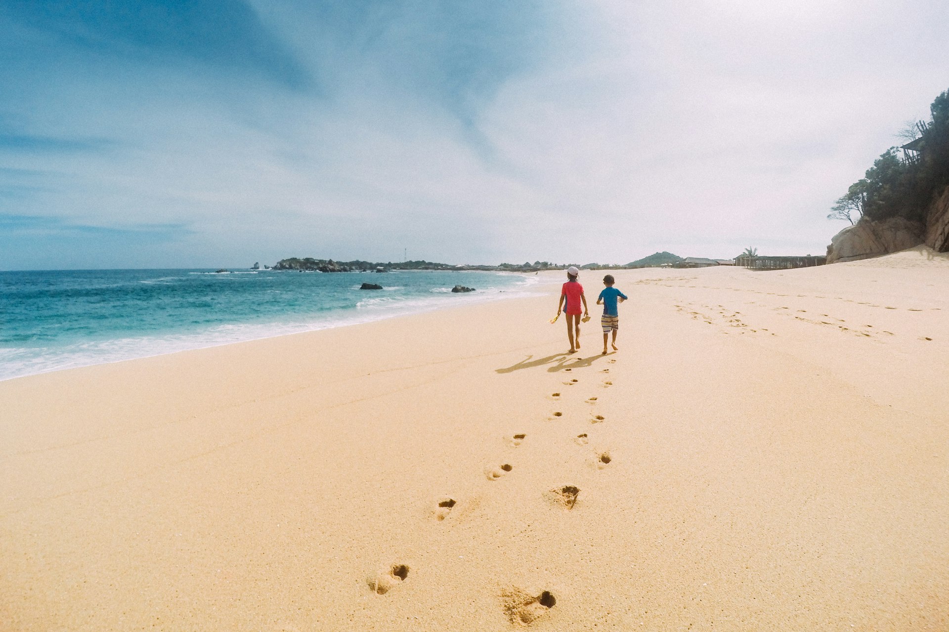 Siblings walk a Deserted Oaxaca Beach in Mexico