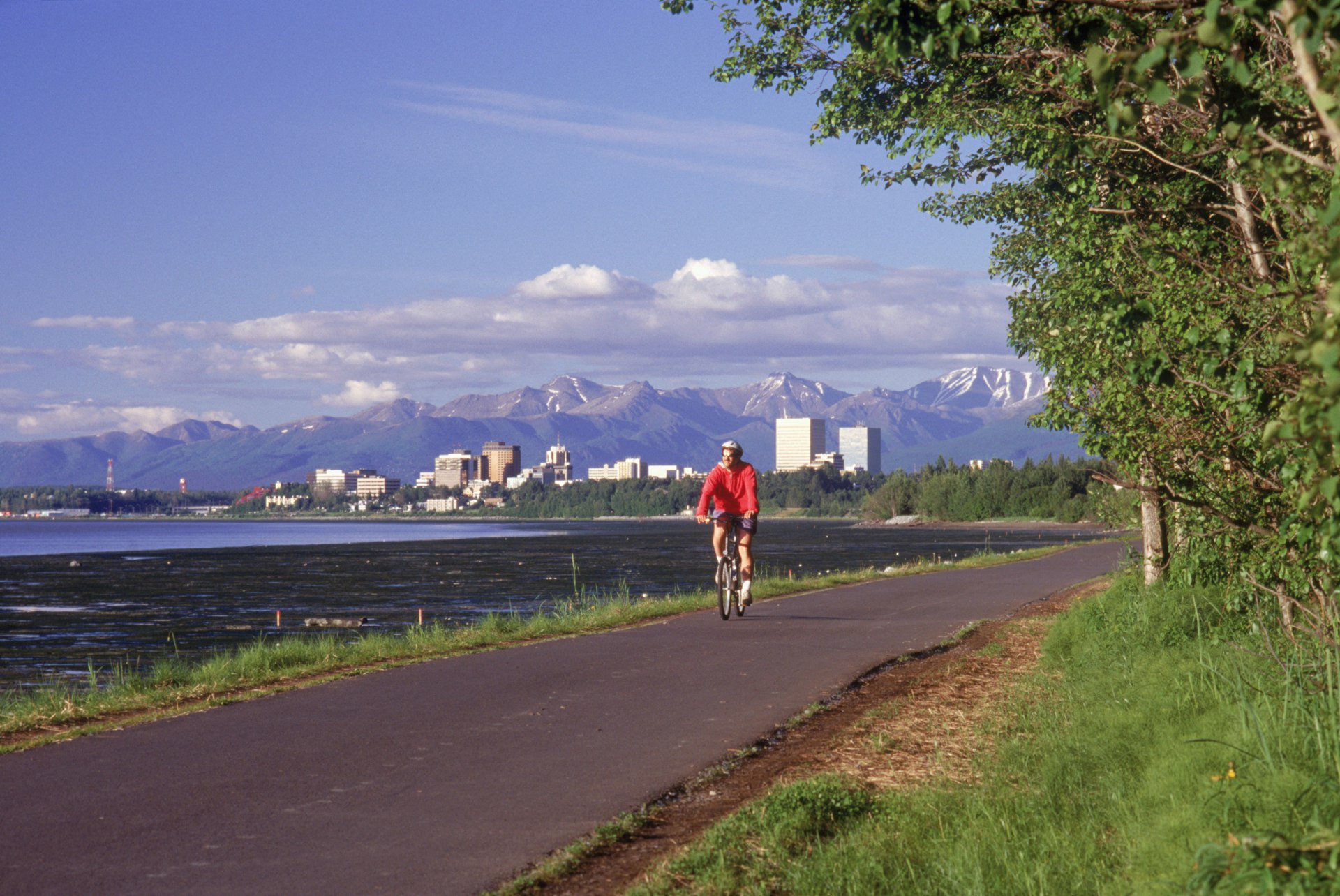 Anchorage skyline w/ bike rider on coastal trail