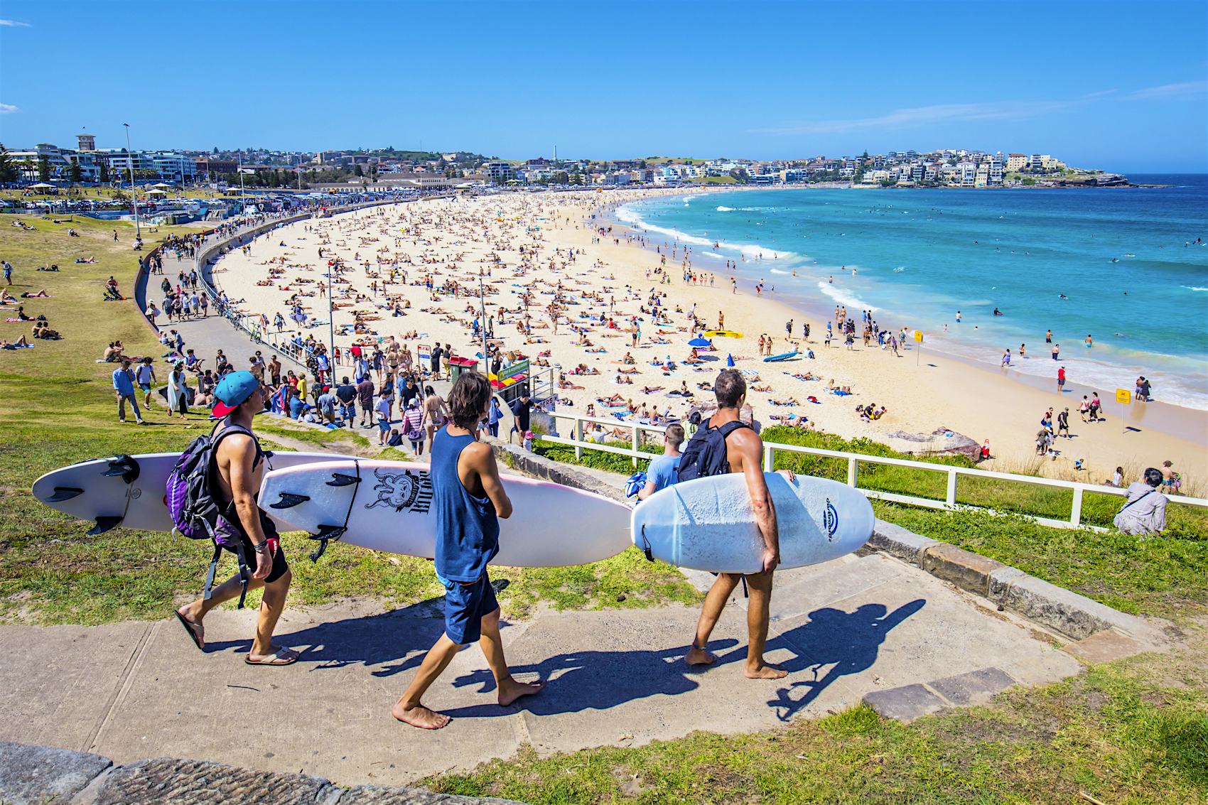 Sydney, Australia - November 19, 2015: Three surfers heading to the Bondi Beach Bondi beach with their surf boards on a sunny day