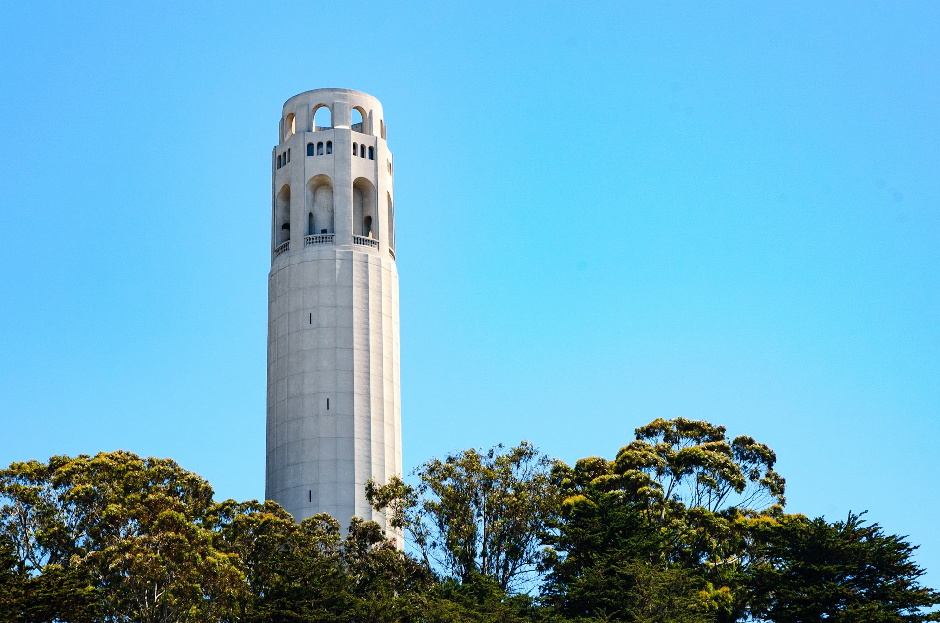 A view of Coit Tower against a blue sky