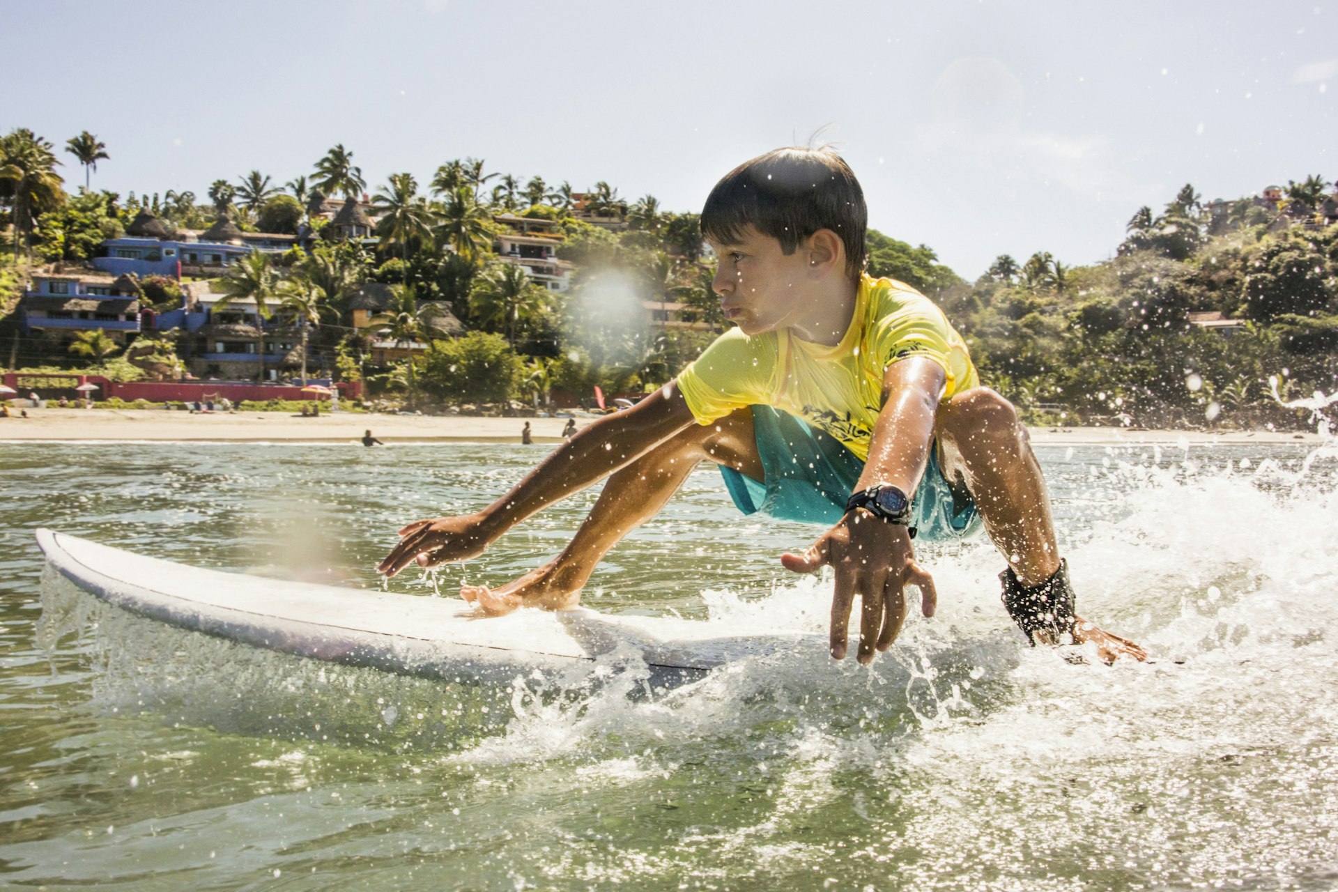 Mixed race boy surfing in ocean