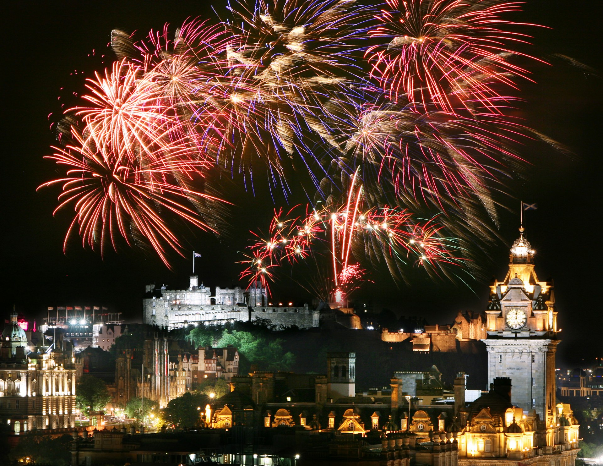 Fireworks over Edinburgh's city center for Hogmanay (New Year’s Eve) during the Edinburgh Festival and Edinburgh Military Tattoo.