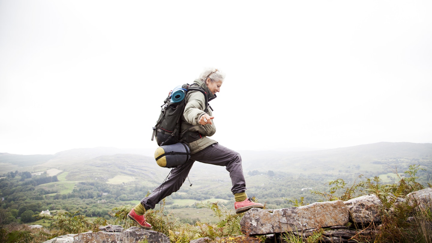 Older woman happily trekking in the mountains around Kenmare.