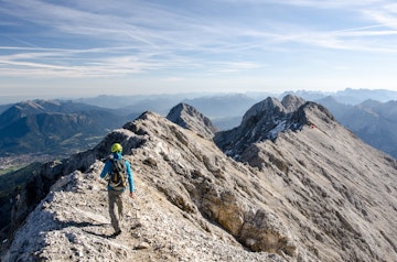 Rear View Of Hiker Walking On Mountain