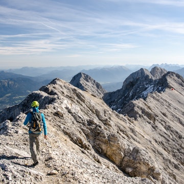 Rear View Of Hiker Walking On Mountain