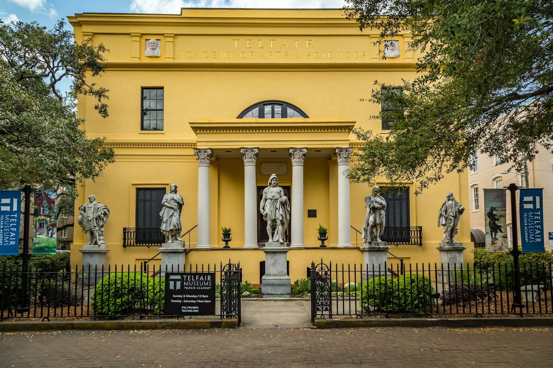 The facade of the yellow Telfair Academy, a historic mansion and museum
