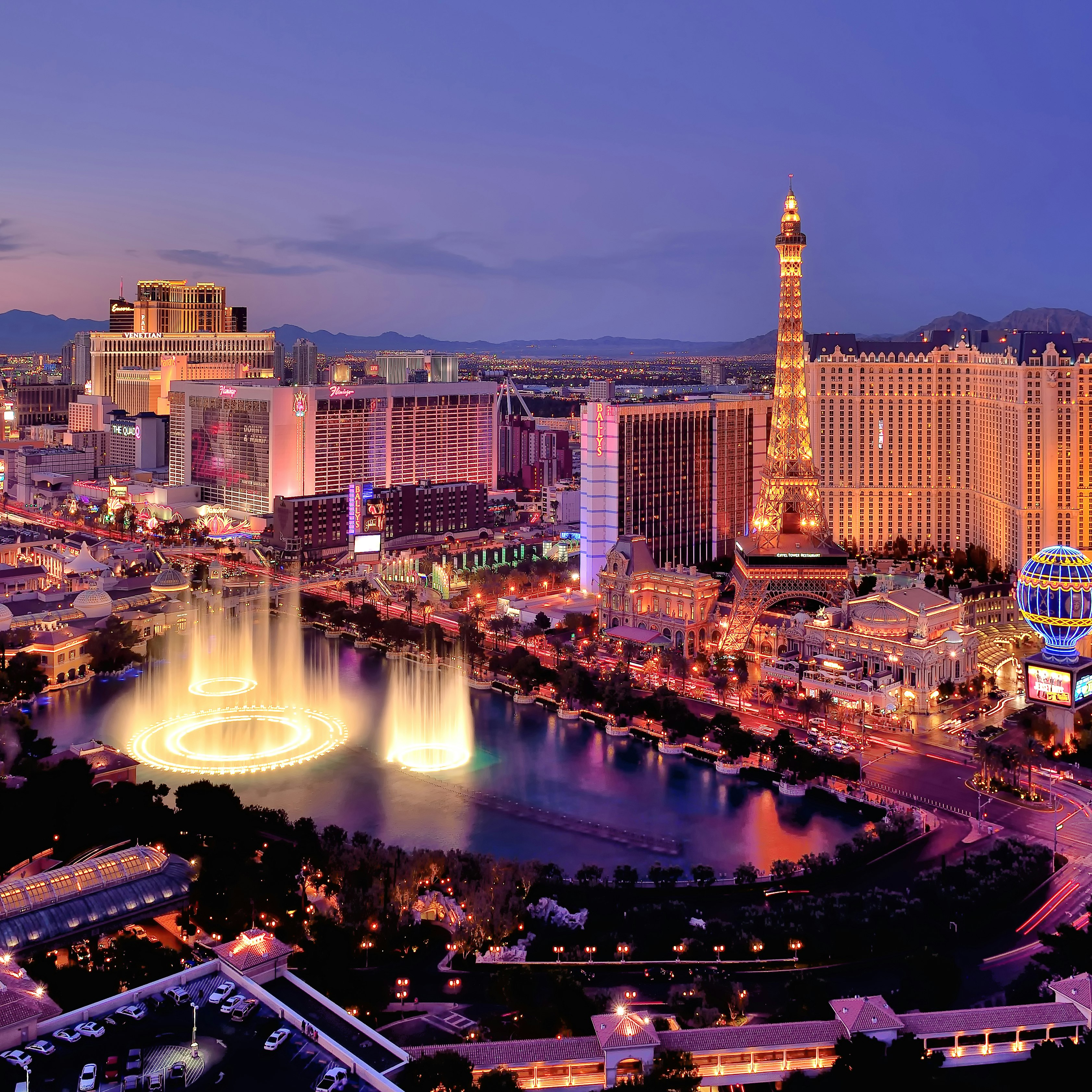 The Las Vegas strip with the fountains of the Bellagio leaping into the air photographed at dusk. 