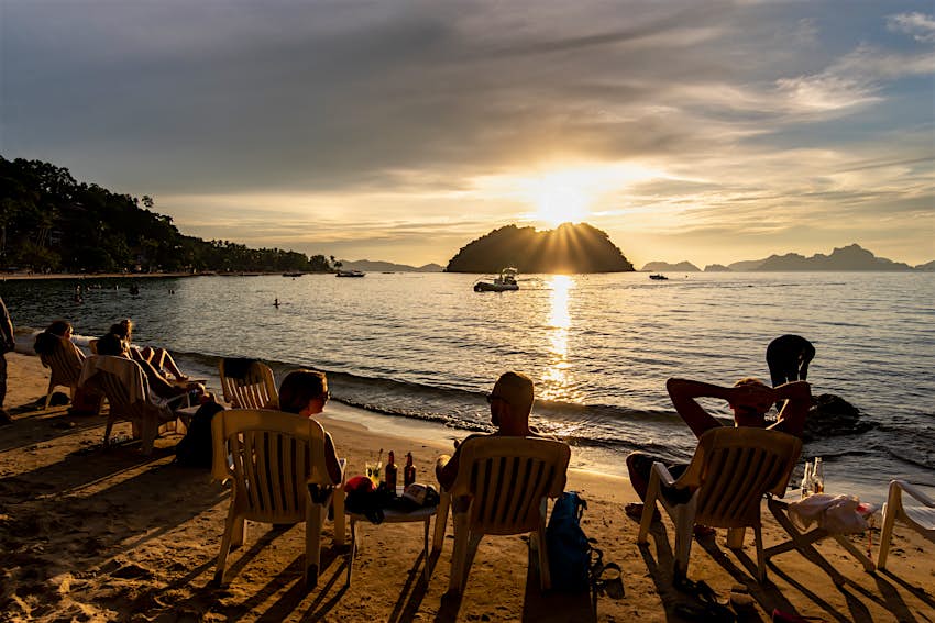 Les gens qui regardent le coucher du soleil sur la plage de Maremegmeg à El Nido, Palawan, Philippines