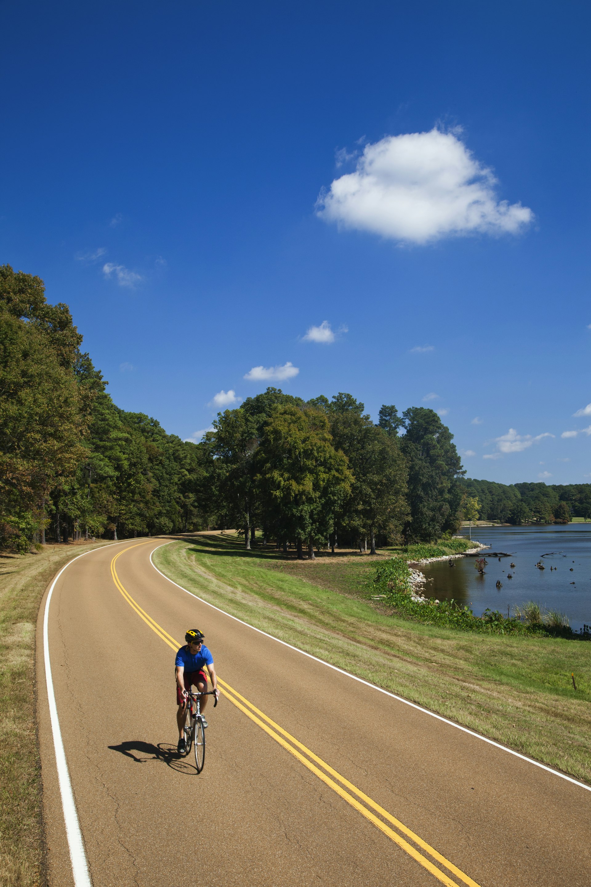 Young man, athletic and fit, rides his road bike on the sunny day, Natchez, Mississippi, USA
