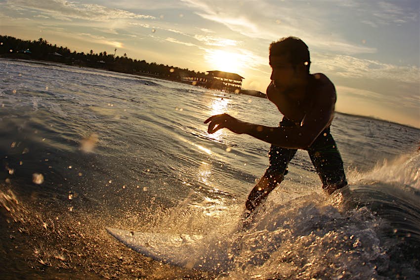 Un surfeur surfe sur une vague à Siargao, aux Philippines