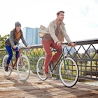Young couple with urban bicycle in city park in Autumn.