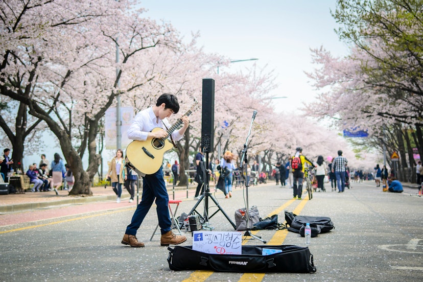 APRIL 10, 2016: A street performer plays guitar at Yeongdeungpo Yeouido Park.