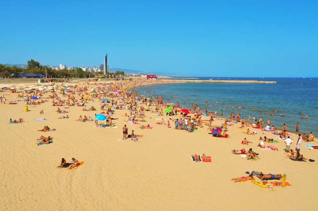 Sunbathers spread out across Nova Icària Beach in Barcelona 
