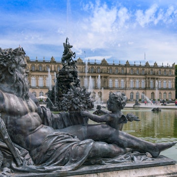 June 25, 2015: Sculptures and a fountain in the castle gardens of Herrenchiemsee New Palace.