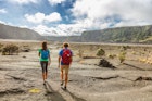 Hiking couple walking on Kilauea Iki crater trail on Big Island.