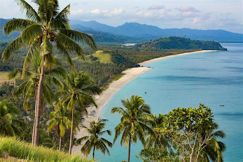 shutterstockRF_1302213154.jpg An aerial view of San Vicente's Long Beach, a long palm-backed stretch of beach lapped by a blue sea.