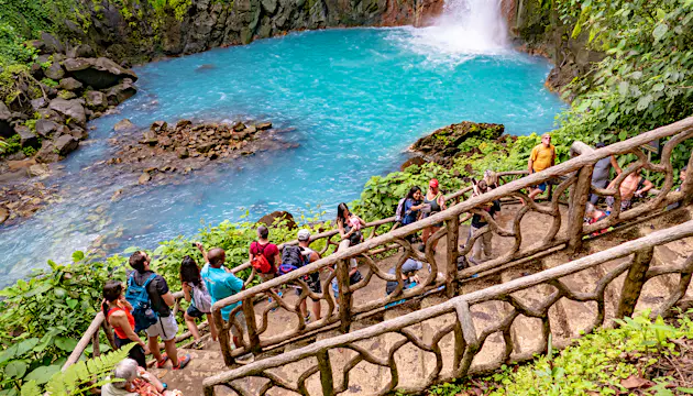 March 1, 2019: Tourists viewing a waterfall from a platform at the Tenorio Volcano National Park.