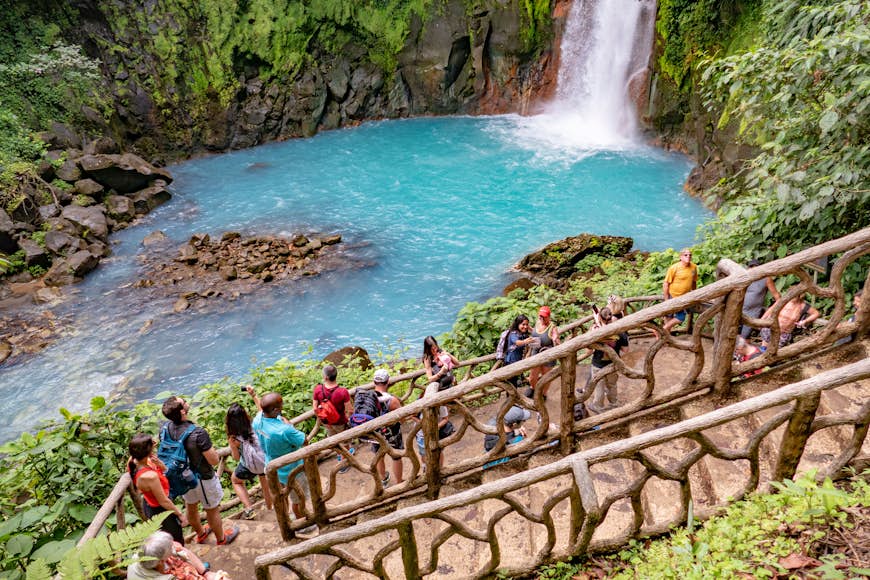 Tourists viewing a waterfall from a platform at the Tenorio Volcano National Park. 