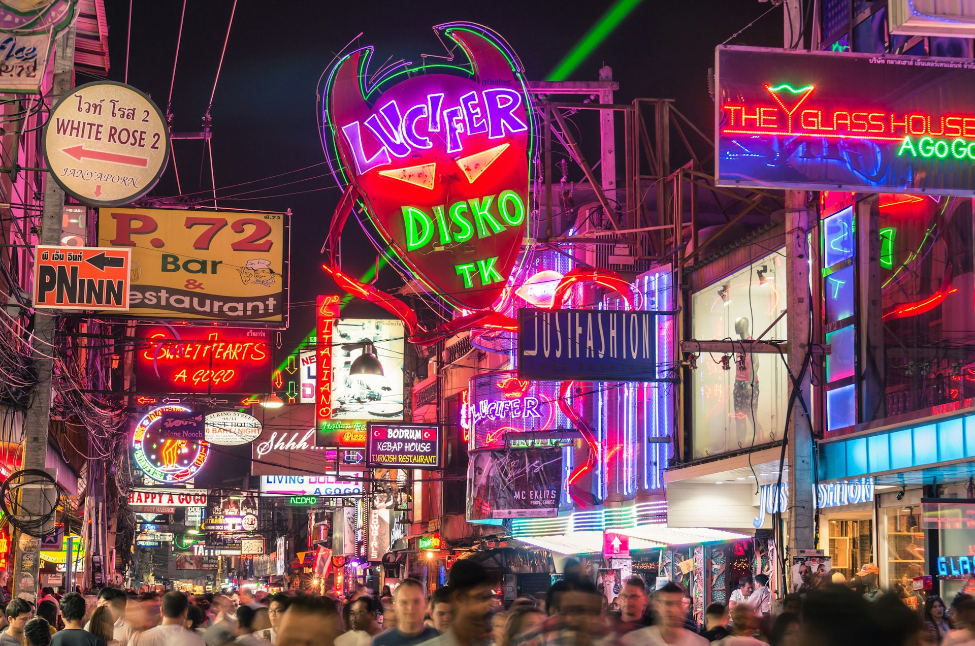 Multicolored neon signs in the heart of the Walking Street in Pattaya. Crowds of people walk through the narrow streets that are lined with bars and restaurants.