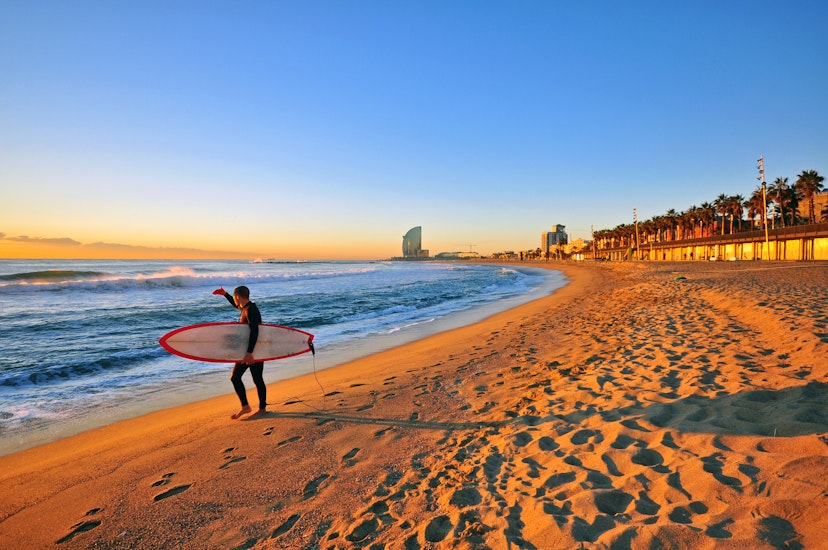 Surfer with a board at dawn on a Barcelona beach on December 30, 2014.