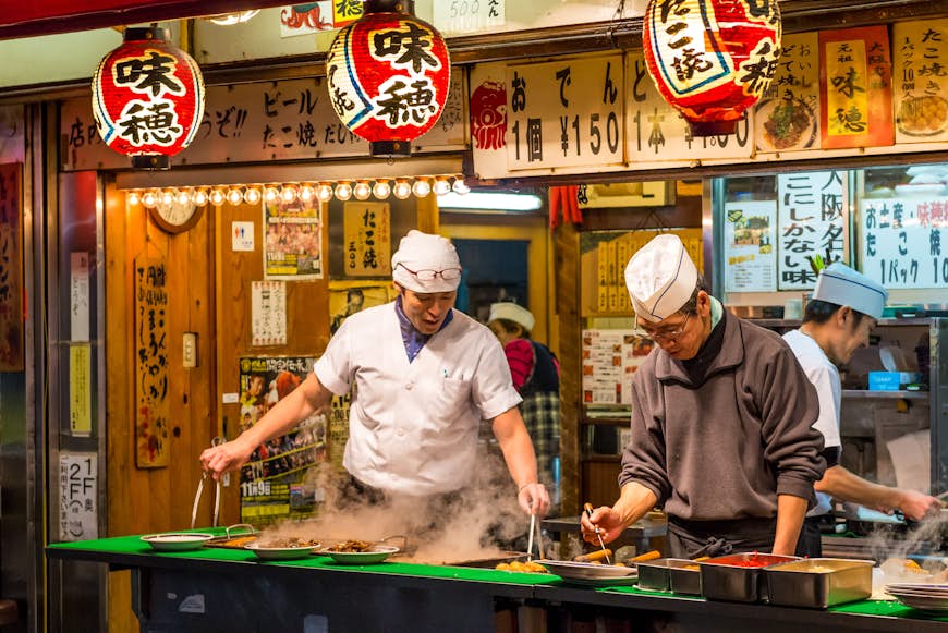 Two chefs cook traditional Japanese street food on in Osaka, Japan