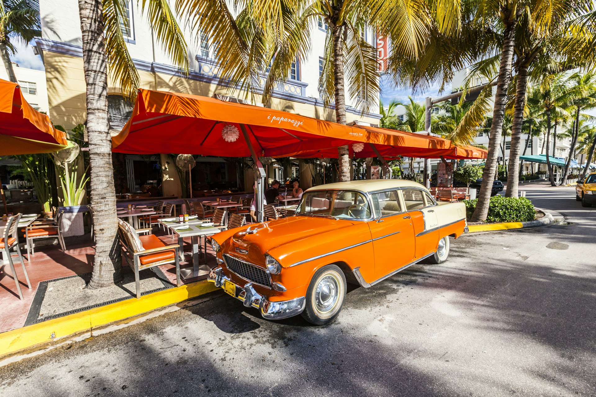 The Art Deco Edison Hotel and a classic Oldsmobile car on Ocean Drive, South Beach, Miami, USA. Classic cars are allowed to park at yellow line.