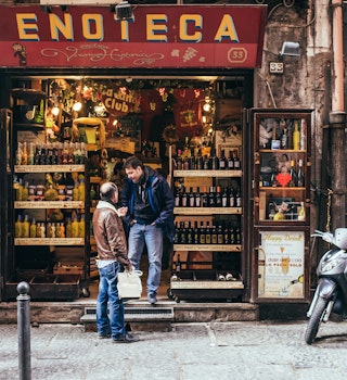 NAPLES, ITALY - MARCH 20, 2015: Range of the wine shop on the old popular street in Naples, Italy