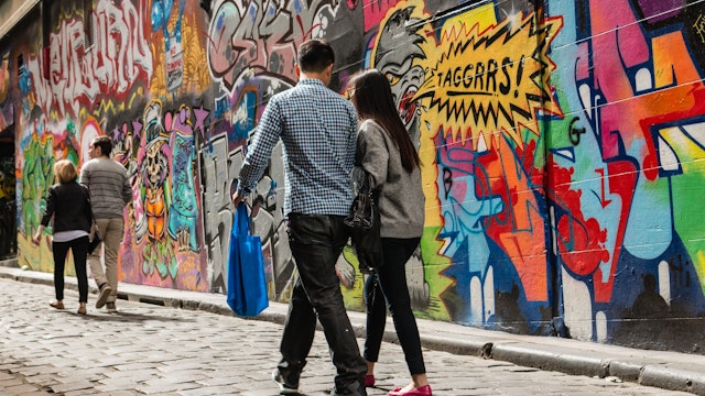 Melbourne, Australia - March 22, 2014: people walking past graffiti wall in Hosier Lane in Melbourne