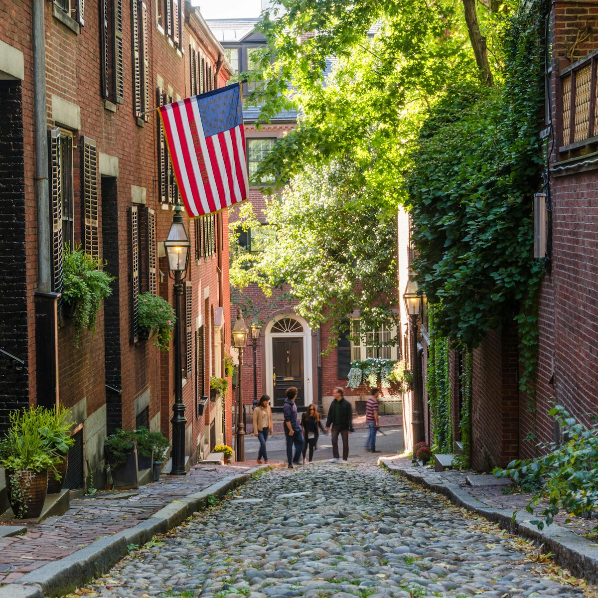 Boston, USA - October 10, 2015: Tourists wandering along Acorn Street in Beacon Hill on a warm autumn day. Beacon Hill is one of the oldest and most picturesque neighborhoods in the United States.