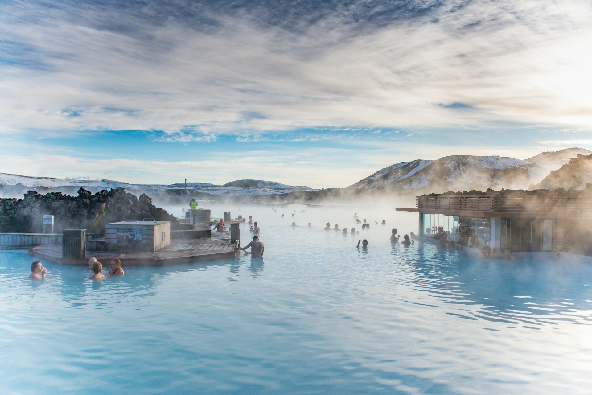 People bath in a blue geothermal pool. 