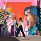 Girlfriends walk past murals in downtown El Paso, Texas