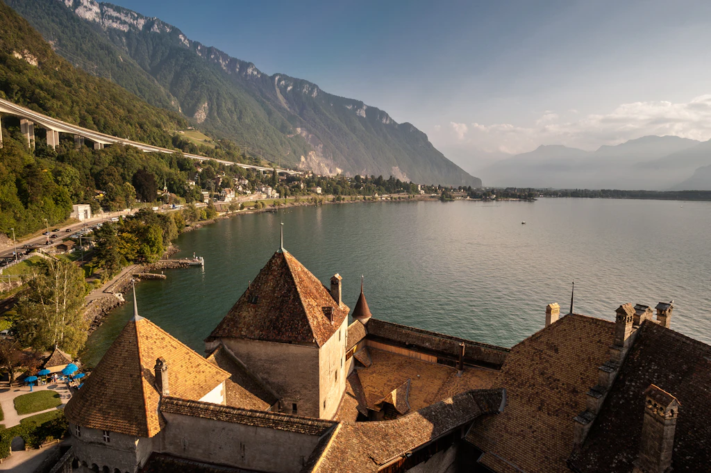 The view from the top of Castle Chillon, overlooking Lake Geneva. In the background, mountains are visible.