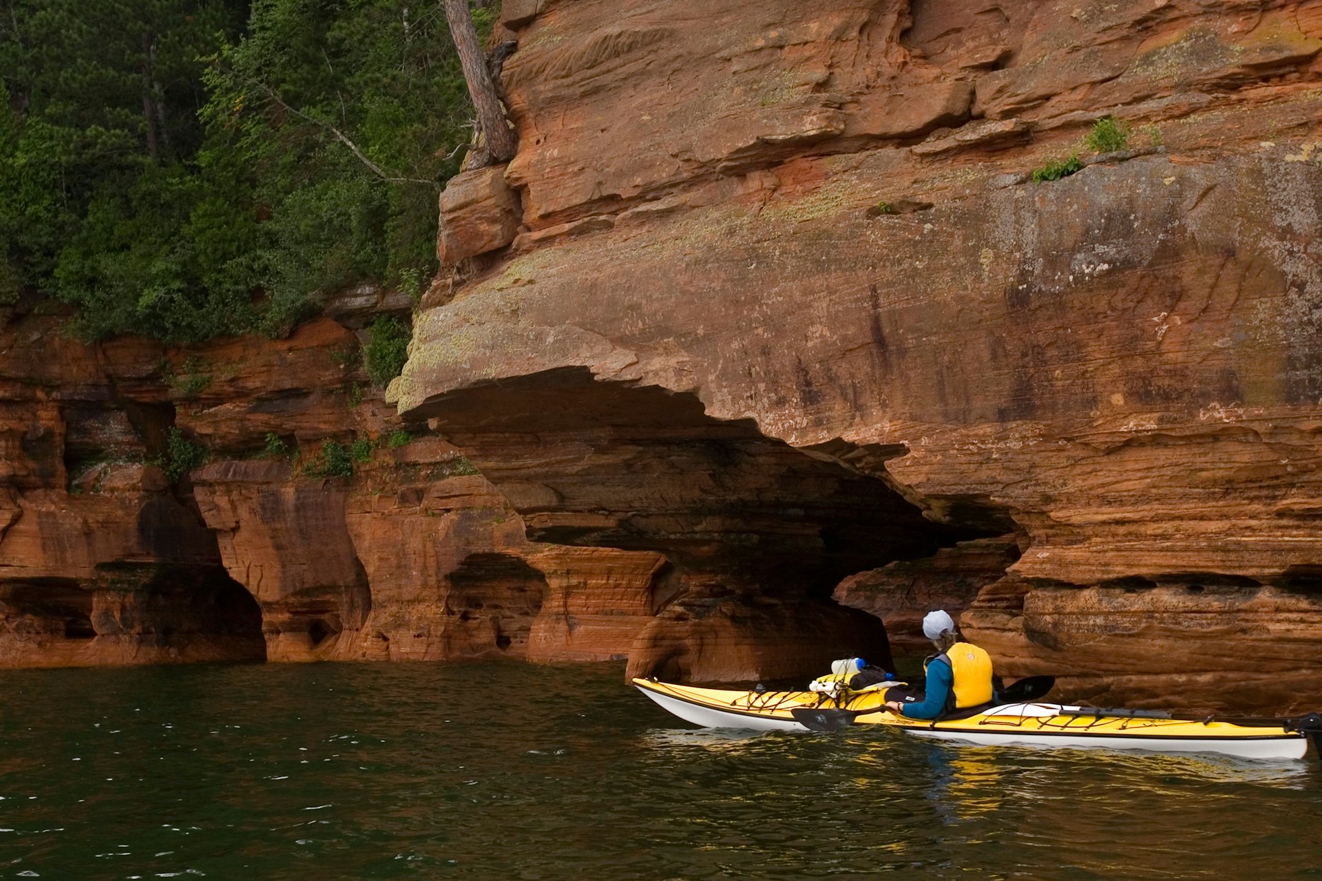 A sea kayaker explores the sea caves at Meyers Beach in the Apostle Islands National Lakeshore near Bayfield, Wisconsin