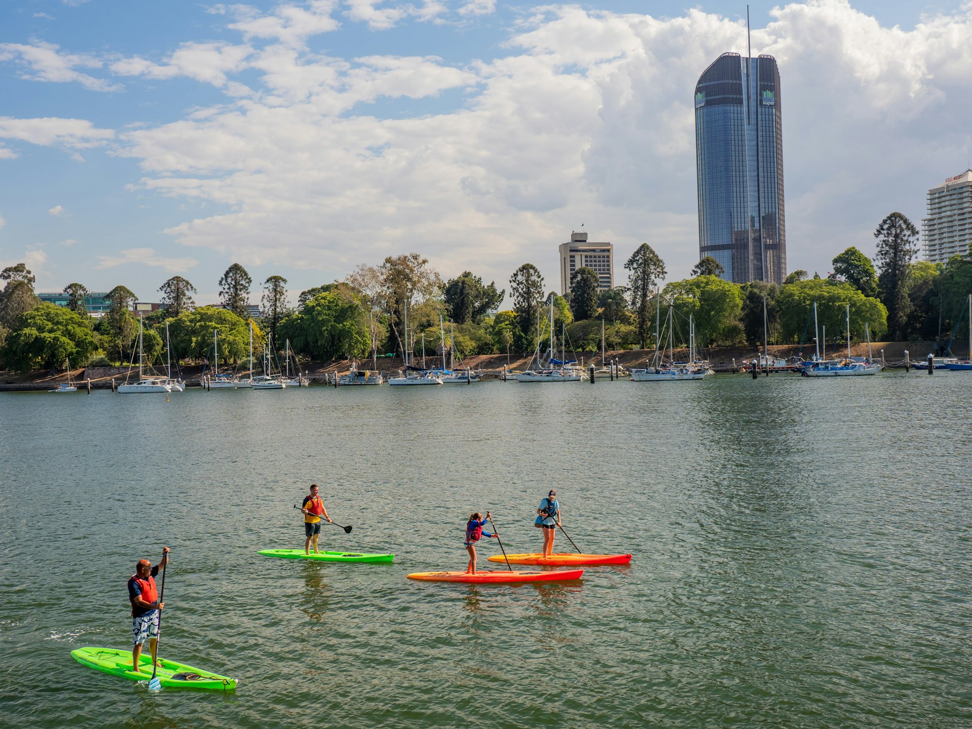 People stand-up paddleboarding on Brisbane River