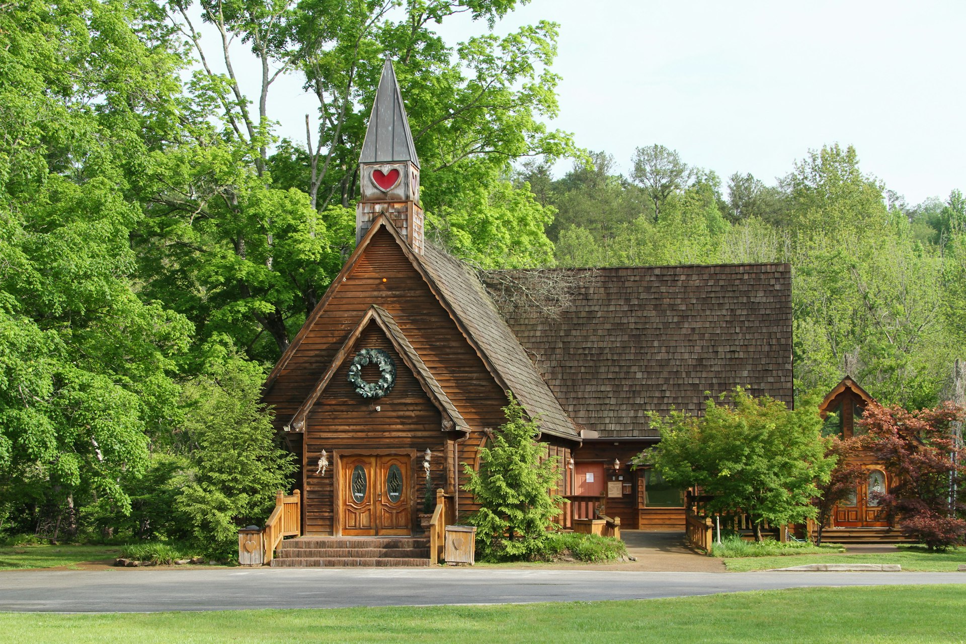 The exterior wooden facade of the Wedding Chapel surrounded by tall trees