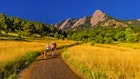 Hikers walking their dogs, The Flatirons rock formations, Chautauqua Park, Boulder, Colorado USA.