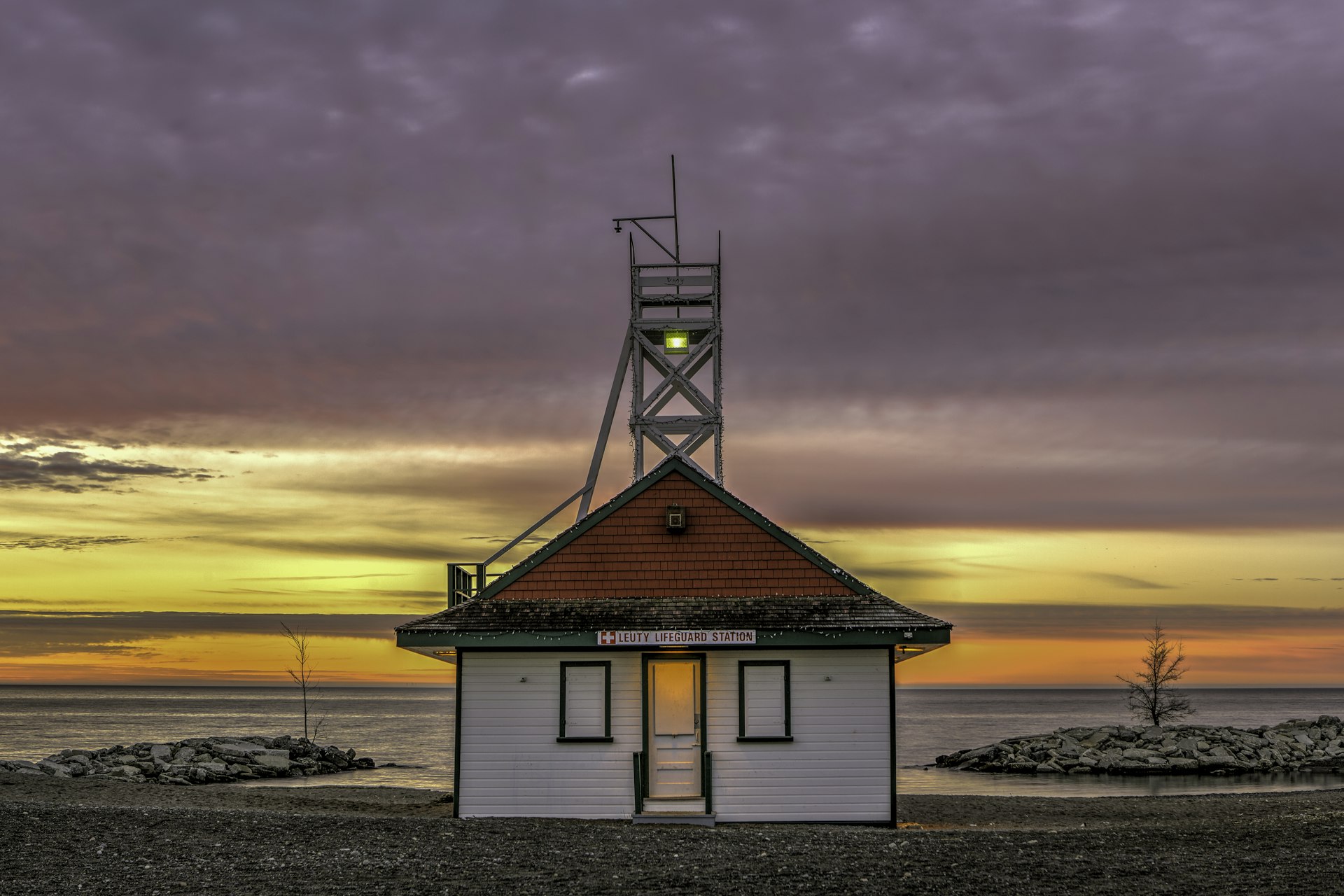 A lifeguard station with a sunrise inthe background