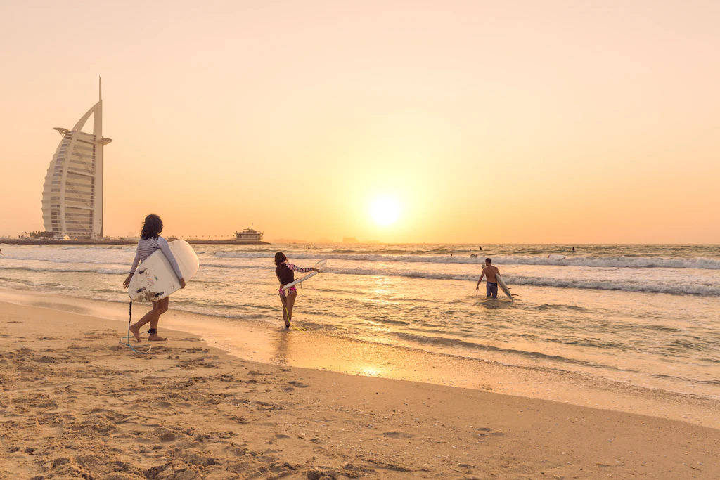 Surfers on a beach near Burj Al Arab in Dubai, United Arab Emirates