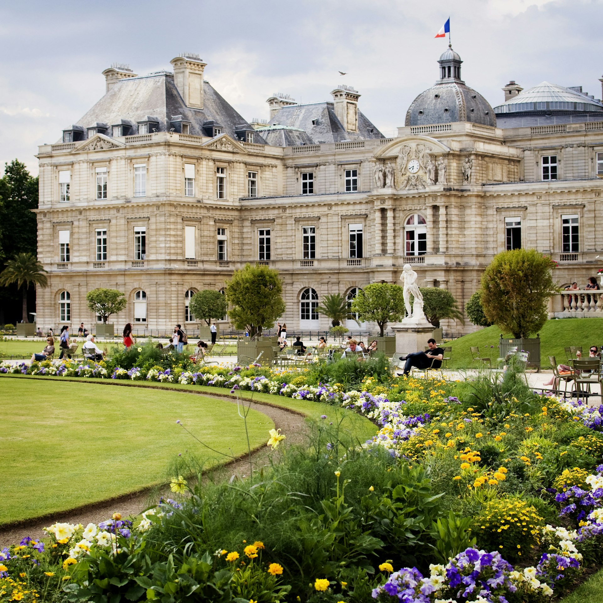 Luxembourg Palace in Jardin du Luxembourg, Paris with blooming flowers in foreground.