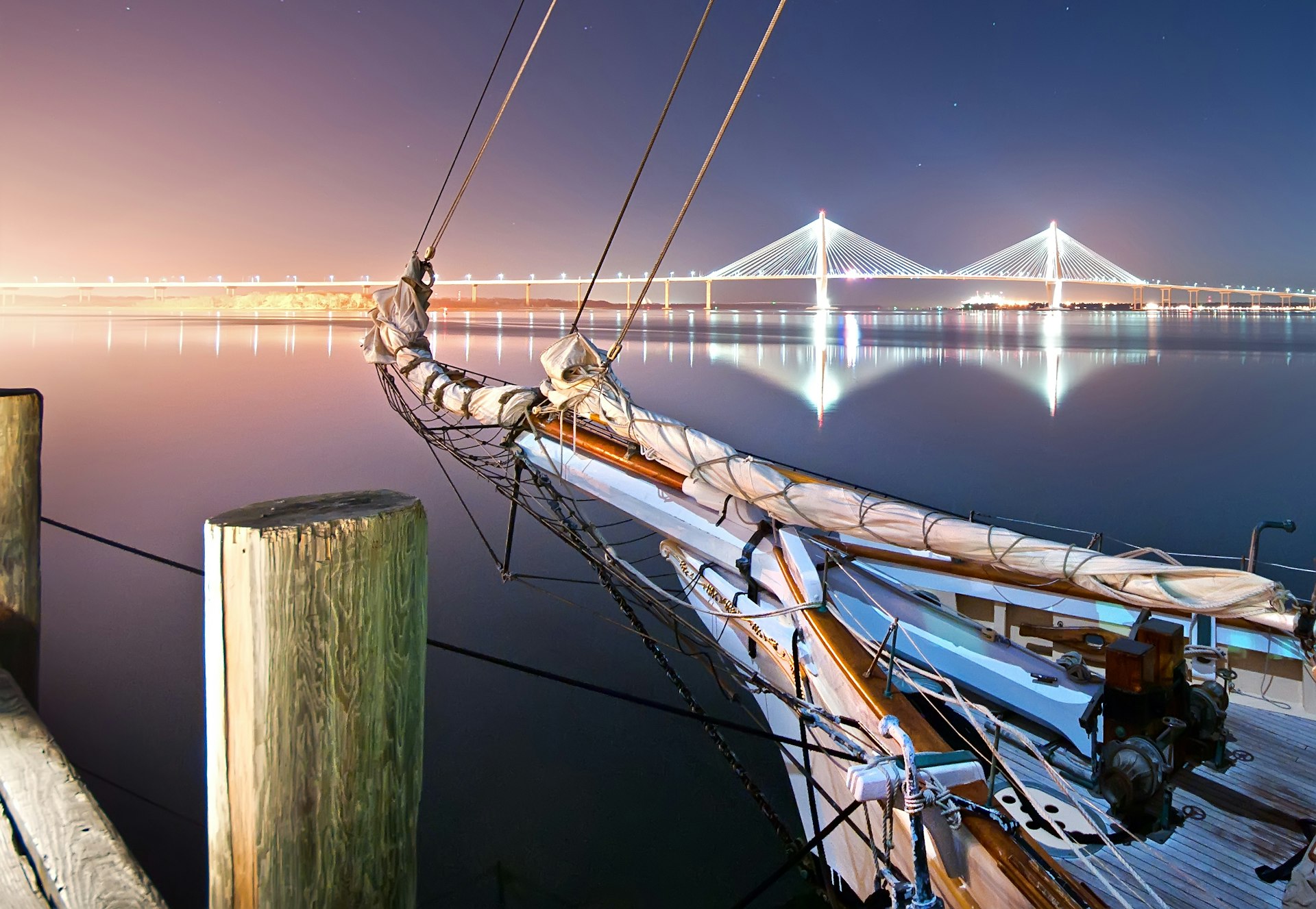 Nightfall over Charleston harbor with the schooner Spirit of South Carolina at dock and the Arthur Ravenel Jr. Bridge in the background.